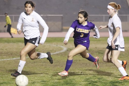 Lemoore's Mia Melendrez splits a pair of Tulare defenders as she helps lead her Tigers to a big win Thursday night in Lemoore.